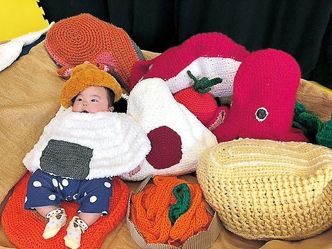 毛糸で編まれた大きな食べ物と赤ちゃん