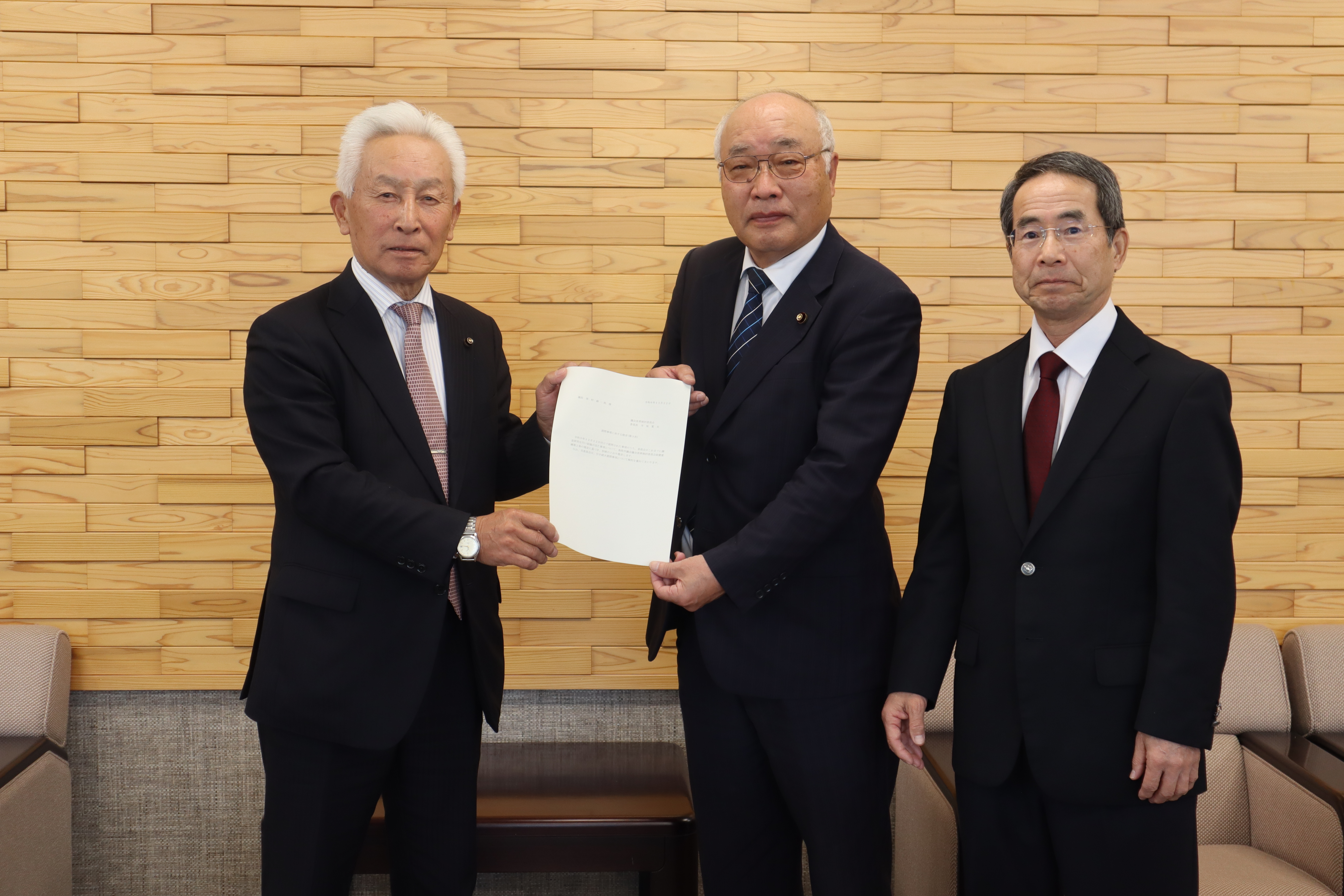 寺坂委員長から西村議長に提言書が手渡される様子の画像