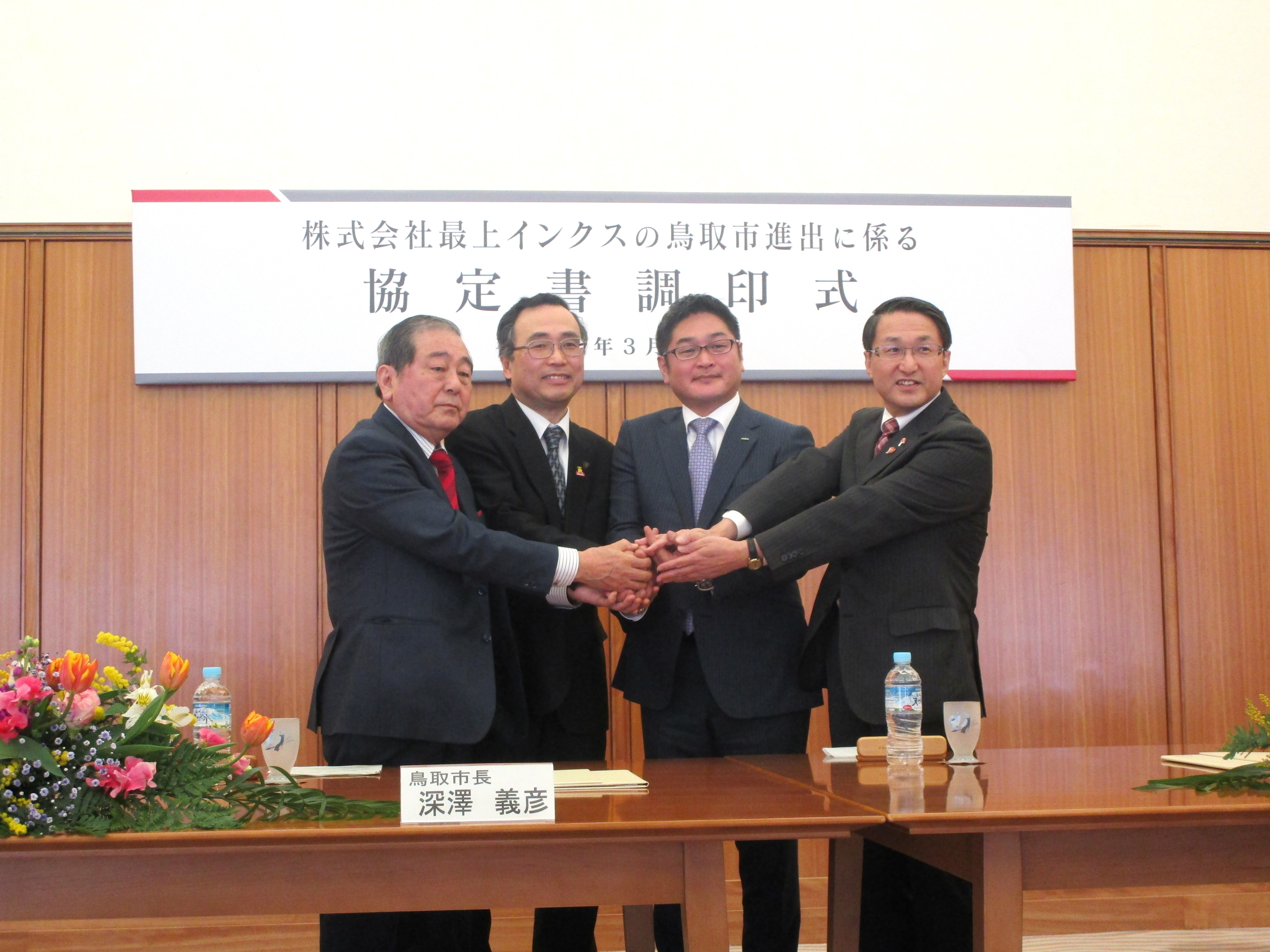 3者による調印後、鳥取商工会議所藤縄会頭を加えた4者による固い握手の様子。
