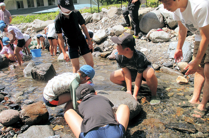 千代南中学の生徒が職場体験で魚のつかみ取りをサポートしている様子