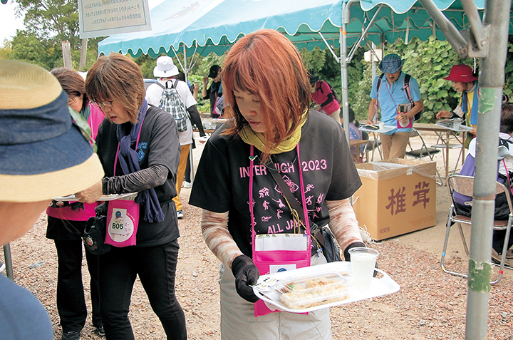 ガストロポイントで地元食材がふんだんに使われた飲食物を受け取る参加者