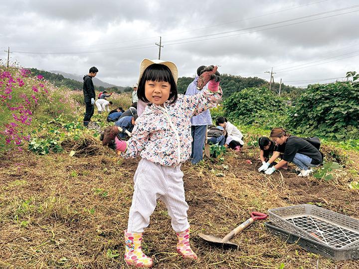 サツマイモを両手に持つ女の子